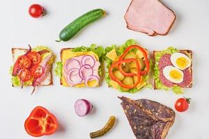 andere Art von Sandwich und Zutaten auf weißem Hintergrund, Ansicht von oben foto