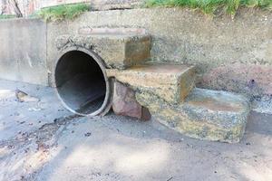 Betonkanal mit Treppe zum Strand. Wasserablaufloch. foto