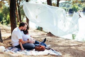 schwangere Frau mit ihrem Mann bei einem Picknick. foto