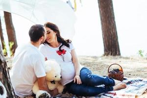 schwangere frau mit ihrem mann beim picknick. glücklich co foto