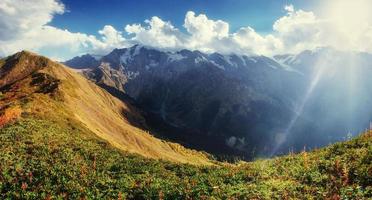 Herbstlandschaft und schneebedeckte Berggipfel. foto