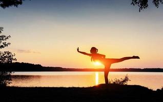 sportlicher auftritt der frau bei sonnenuntergang am wasser foto