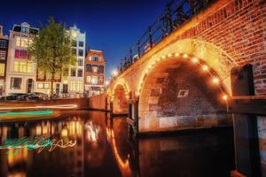 Kanal in Amsterdam bei Nacht. Hervorhebung von Gebäuden und Straßen foto