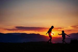 Kinder spielen bei Sonnenuntergang