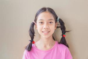 Headshot-Frontporträt eines glücklichen asiatischen Mädchens, das in die Kamera schaut