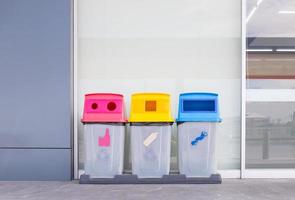 Gruppe bunter Papierkörbe, verschiedenfarbige Behälter zum Sammeln von Recyclingmaterialien. Mülltonnen mit Müllsäcken in verschiedenen Farben. umwelt- und abfallwirtschaftskonzept.