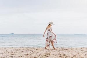 asiatische junge Frau zu Fuß am Strand foto