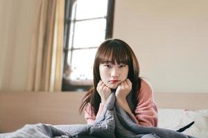 Wellness-Lifestyle der asiatischen Teenager-Frau wacht im Schlafzimmer auf. foto