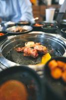 Restaurant im koreanischen Grillstil mit Fleisch- und Gemüsebeilagen. foto