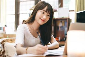 asiatische Teenager-Frau bleibt zu Hause und nutzt das Internet für Arbeit und Studium foto