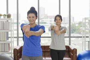 Zwei asiatische Frauen mittleren Alters machen Yoga in ihrem Haus. foto