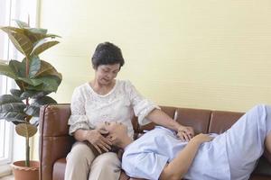 die asiatische tochter, die im krankenhaus krank war, hatte ihre mutter zur unterstützung neben sich und saß in einem speziellen raum auf dem sofa. foto