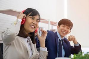 Zwei asiatische männliche und weibliche Büroangestellte necken sich gegenseitig mit Spaß im Büro. foto