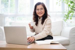 Bild einer älteren asiatischen Geschäftsfrau, die zu Hause arbeitet foto