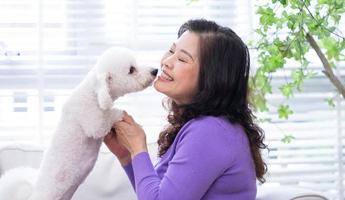 Porträt einer älteren Frau, die ihren Hund umarmt foto