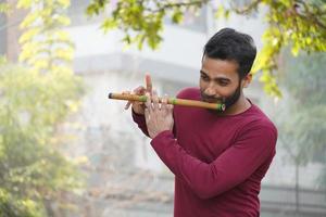 Mann spielt Flöte - indisches Musikinstrument foto