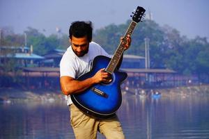 Mann spielt Gitarre auf dem Boot. foto