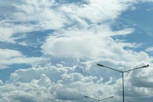 weiße wolken im blauen himmel und straßenlaterne foto