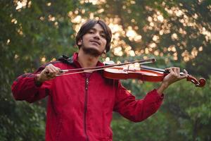 Mann, der Geige spielt. klassisches Musikinstrument. Teenager üben foto