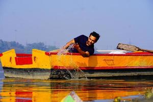 Mann genießt mit Wasser im Boot sitzen foto