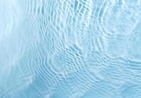 verschwommene, transparente, blau gefärbte Wasseroberfläche foto