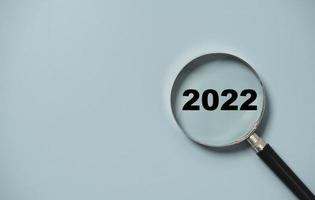2022 Jahr Nummer Insider des Lupenglases auf blauem Hintergrund für Fokus-Neujahrs-Geschäftskonzept. foto