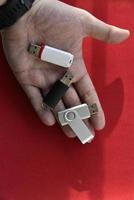 USB-Flash-Laufwerk in der Handfläche auf rotem Hintergrund foto