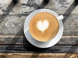 Herz Latte Art auf Kaffeetasse auf Holztisch foto