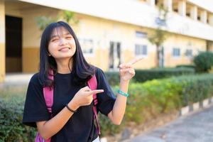 Studentin junges Mädchen hält rosa Buch und Rucksack in der Schule, zurück zur Schule. foto