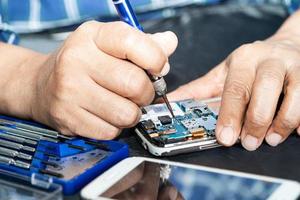 Techniker, der das Innere des Mobiltelefons durch Lötkolben repariert. Integrierter Schaltkreis. das Konzept von Daten, Hardware, Technologie. foto