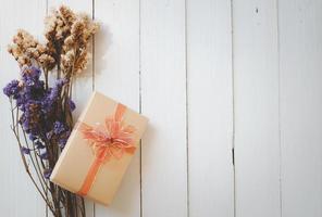 Sträuße aus violetten und weißen Statice-Blumen und goldenen Geschenkboxen isoliert auf weißem Holzhintergrund mit Kopierraum für Text. foto