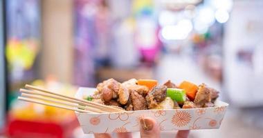 Gebratenes schwarzes Schweinefleisch auf dem traditionellen Markt Koreas, köstliche koreanische Küche mit Karotten und Schalotten, Frühlingszwiebeln, Nahaufnahme, Kopierraum foto