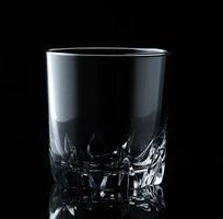 Glas Wasser oder Whisky und Wein. leeres Glas für alkoholische Getränke auf schwarzem Hintergrund. foto