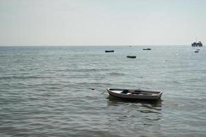 Einzelboot mit Meer- und Strandblick mit anderen Booten im Hintergrund foto