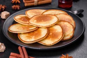 Köstliche frische Pfannkuchen auf einem Holzschneidebrett mit Zucker foto