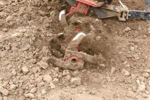 Ein kleiner Ackerschlepper pflügt den Boden, die Arbeit eines handgeführten Traktors foto