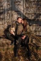 Schönes Paar, das den Herbsttag im Freien mit seinem Hund verbringt foto