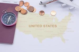 Passkompass und Münzen auf einer amerikanischen Karte. Geschäftsreisekonzept foto