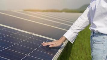 nahaufnahme des handingenieurs, der mit photovoltaikzellenfarm oder sonnenkollektorfeld, umweltfreundlicher und sauberer energie berührt. foto