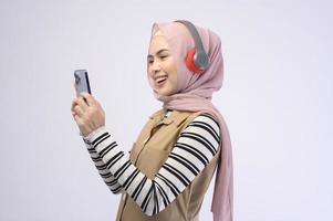 junge beautifu muslimische Frau mit Headset auf weißem Hintergrund foto