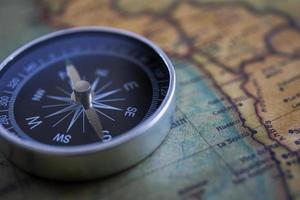 Kompass auf dem Hintergrund, alte Weltkarte, Vintage-Stil, Geonavigationskonzept. foto