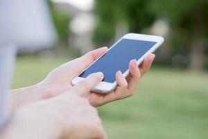 hände der frau mit smartphone im garten foto