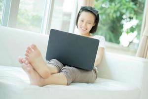 Casual junge Frau mit Laptop im Wohnzimmer zu Hause foto