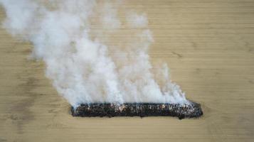 luftaufnahme von verbranntem land auf dem feld nach brand mit asche und rauch foto