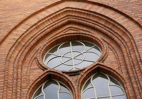 das Fenster der alten Kirche mit Backsteinmauern foto