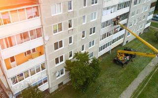 Reparatur der Fassade eines mehrstöckigen Gebäudes mit einem Turmdrehkran foto