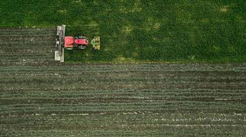 ein traktor mäht ein feld von luftaufnahmen mit drohne foto