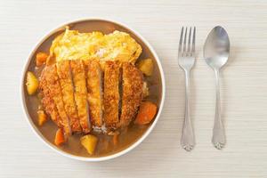 Curryreis mit gebratenem Schweinekotelett und cremigem Omelett foto