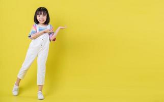Bild in voller Länge des asiatischen Kindes, das auf gelbem Hintergrund aufwirft foto