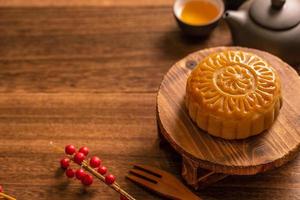 Mondkuchen Mondkuchen-Tischdekoration - rundes chinesisches traditionelles Gebäck mit Teetassen auf Holzhintergrund, Mitte-Herbst-Festival-Konzept, Nahaufnahme. foto